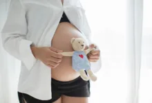 nėščia moteris laiko žaisliuką