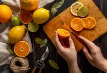 moteris pjausto apelsiną