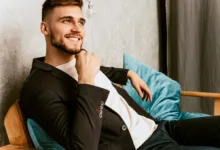 jaunas vyras sėdi ir šypsosi