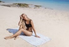 mergina paplūdimyje mėgaujasi saule