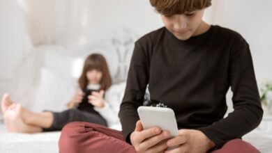 vaikas laiko telefoną rankoje