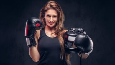 graži moteris su bokso pirštinėmis šypsosi