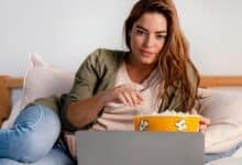 mergina valgo spragėsius ir žiūri filmą