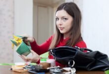 moteris laiko tuščią piniginę rankose