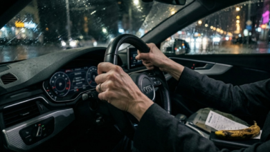 Moters rankos stipriai sugniaužusios vairo odą tamsiame automobilio salone