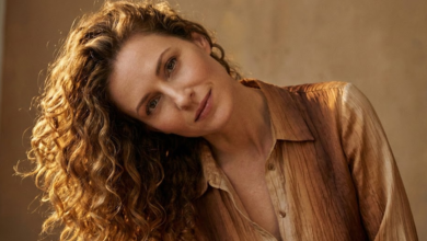 Moteris su tobulo kritimo, žvilgančiomis ir elastingomis natūraliomis garbanomis, lengvai pakreipusi galvą