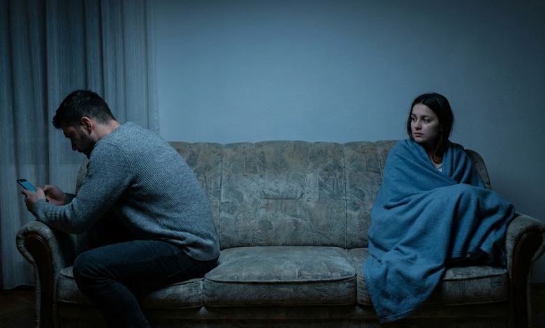 Vėlyvas vakaras, neryškus apšvietimas svetainėje. Ant sofos sėdi pora, tačiau tarp jų – didelis fizinis tarpas