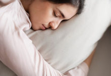 jauna moteris miega patogiai ant pagalvės