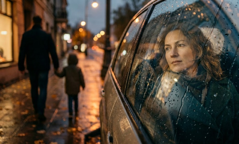 Moteris sėdi automobilyje. Lauke matomas neryškus vyro ir mažo berniuko siluetas, jie eina susikibę rankomis