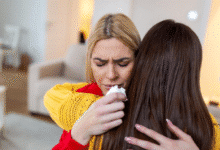 dvi draugės apsikabinusios, viena ramina kitą