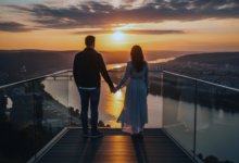 pora stovi apžvalgos aikštelėje saulėdžio fone prie upės