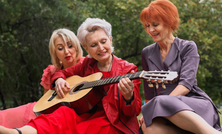 pusamžė moteris groja gitara draugėms