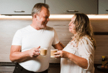 pagyvenusi pora virtuvėje geria kavą