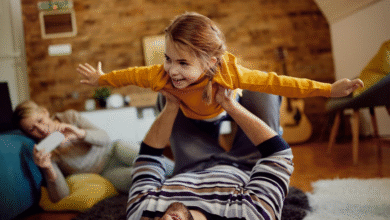 tėtis žaidžia su dukra, o mama fotografuoja