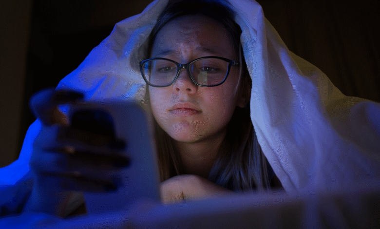 mergaitė lovoje su išmaniuoju telefonu prieš miegą