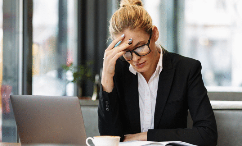 moteris sėdi ofise pasirėmusi ranka galvą