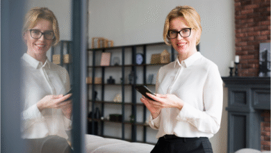 moteris stovi patalpoje ir jos atvaizdas atsispindi stikle