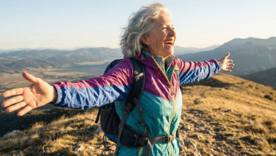 moteris žygiuoja kalnuose ir džiaugiasi laisvės pojūčiu
