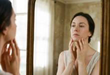 moteris apžiūrinėja savo veido odą veidrodyje