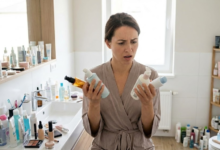 moteris pasimetusi apžiūrinėja savo kosmetikos priemones