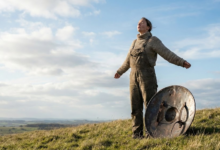 moteris pievoje pasidėjo skydą ir mėgaujasi gaiviu oru