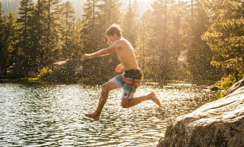 paauglys nuo akmens šoka į vandenį