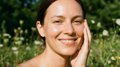 švytintis moters veidas iš arti pievoje